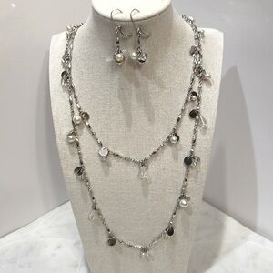 Long silver necklace with pearl and crystal accents and matching earrings.